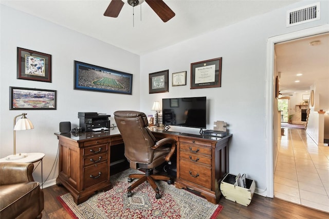 office space with baseboards, dark wood-type flooring, visible vents, and a ceiling fan