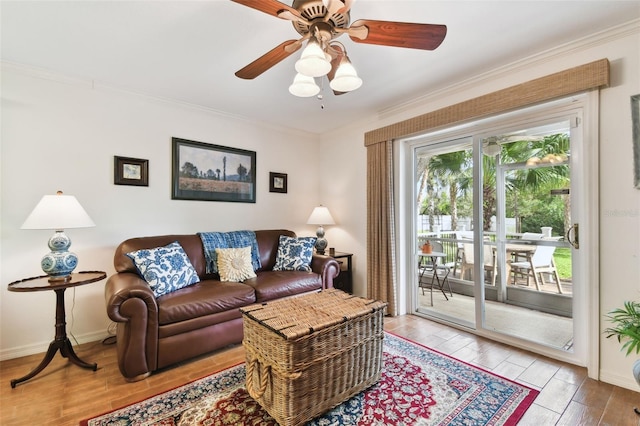 living area featuring light wood finished floors, baseboards, and crown molding