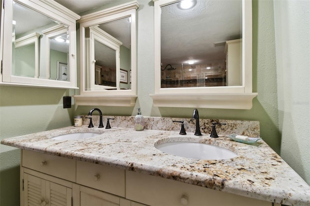 full bathroom with double vanity, a sink, and a textured wall