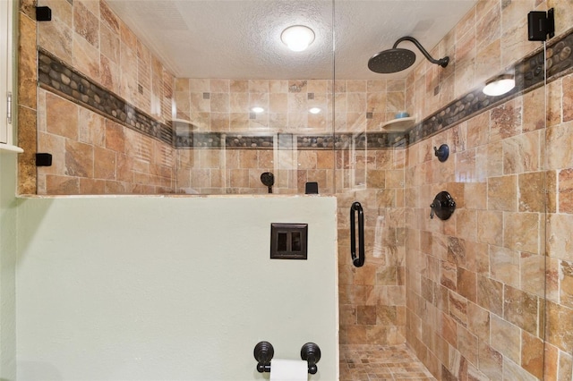 full bath featuring a shower stall and a textured ceiling