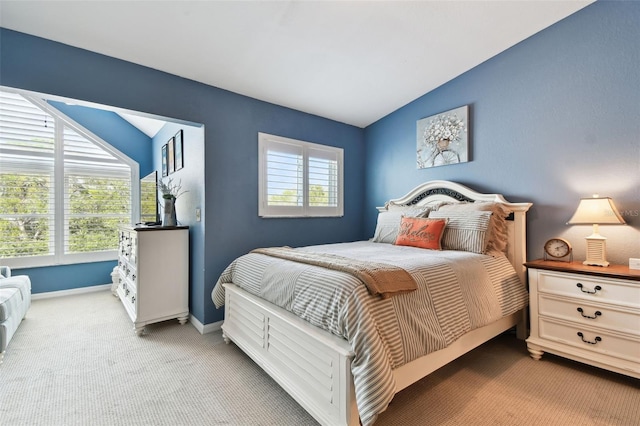 bedroom featuring light carpet, multiple windows, vaulted ceiling, and baseboards