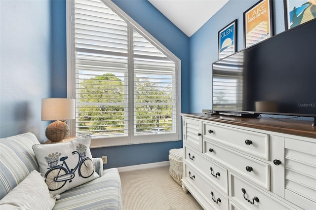 living area featuring light carpet and baseboards