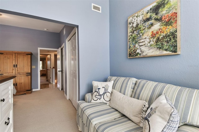 living area with visible vents and light colored carpet