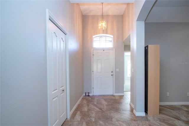 entrance foyer featuring an inviting chandelier, arched walkways, and baseboards