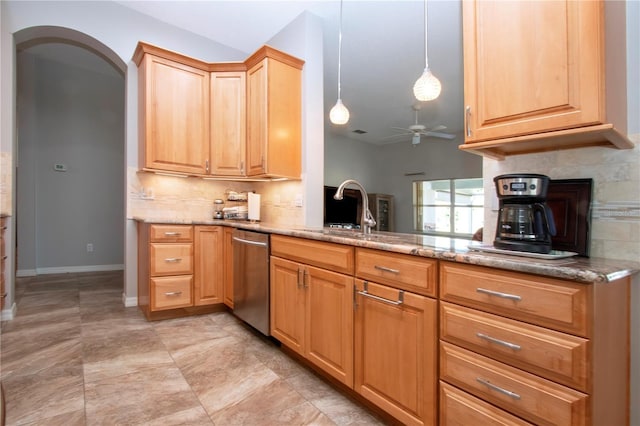 kitchen with a sink, tasteful backsplash, arched walkways, light stone countertops, and dishwasher