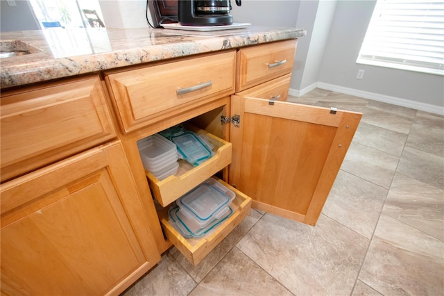 details featuring a sink, baseboards, and light stone countertops