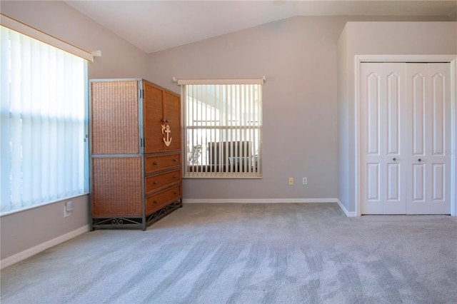 unfurnished bedroom with vaulted ceiling and multiple windows