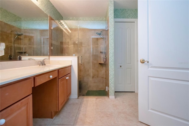 full bathroom featuring vanity, a shower stall, tile patterned floors, and a textured ceiling