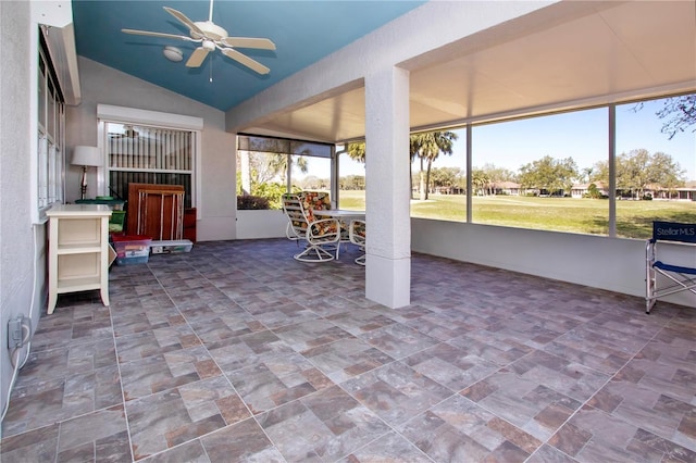 unfurnished sunroom featuring vaulted ceiling and a ceiling fan