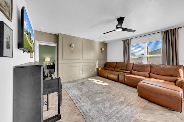 living area featuring a textured ceiling, ceiling fan, and visible vents