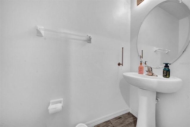 bathroom with baseboards and wood finished floors