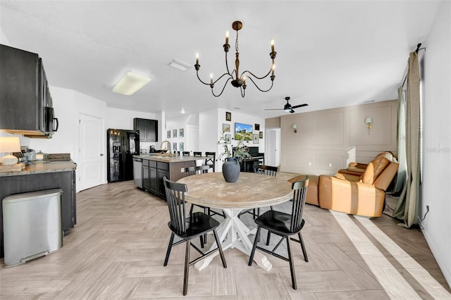 dining space featuring ceiling fan with notable chandelier