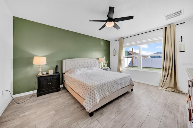 bedroom featuring baseboards, visible vents, a ceiling fan, and wood finish floors