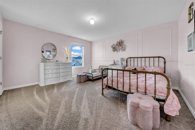 carpeted bedroom with baseboards and a decorative wall