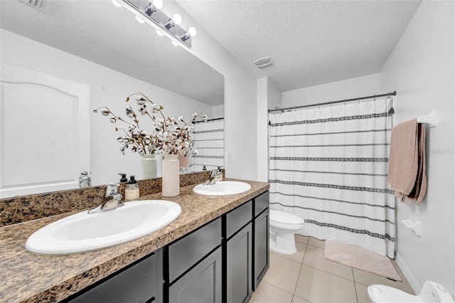 bathroom with a textured ceiling, tile patterned flooring, a sink, and toilet