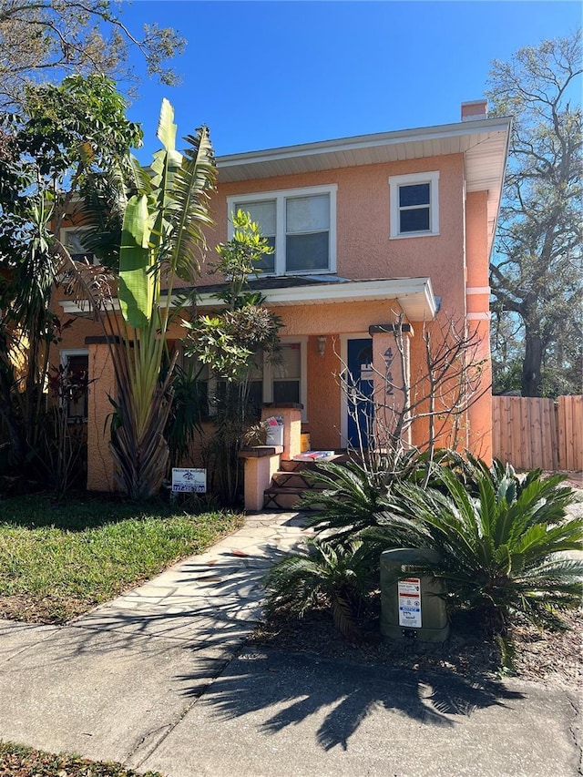 view of front facade featuring fence and stucco siding