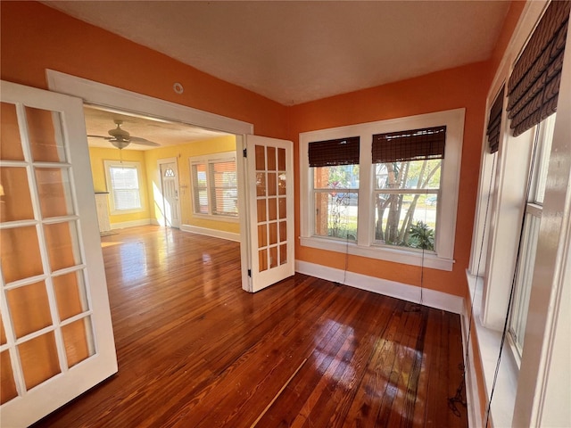 unfurnished room featuring a ceiling fan, baseboards, and wood finished floors