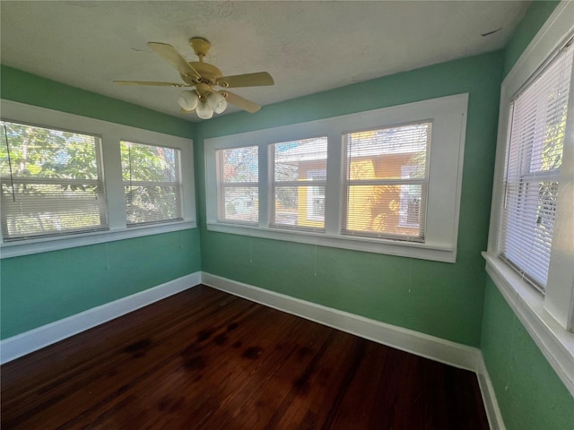 unfurnished sunroom with a ceiling fan