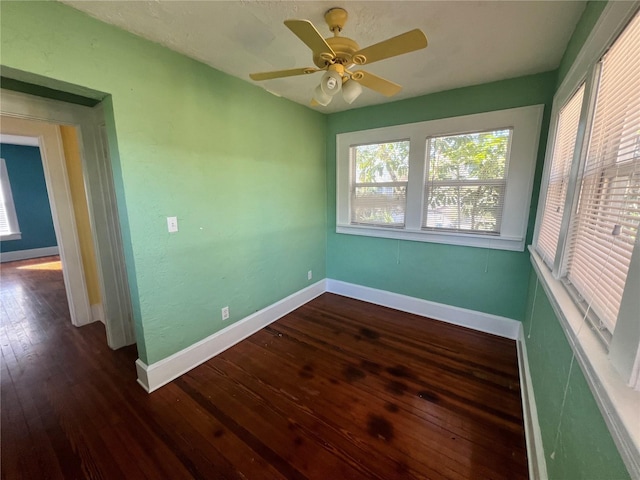 spare room featuring ceiling fan, wood finished floors, and baseboards