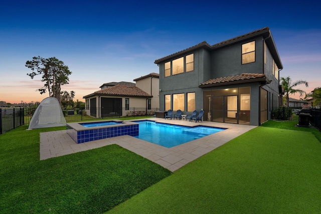 rear view of house featuring a patio, a lawn, and a fenced backyard