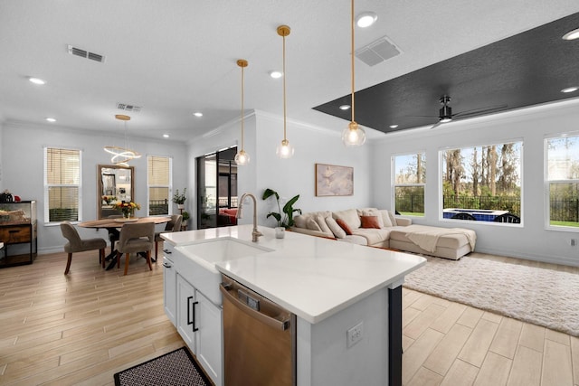 kitchen with a sink, visible vents, open floor plan, and dishwasher