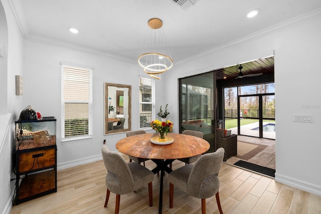 dining room with light wood-style floors, plenty of natural light, and ornamental molding