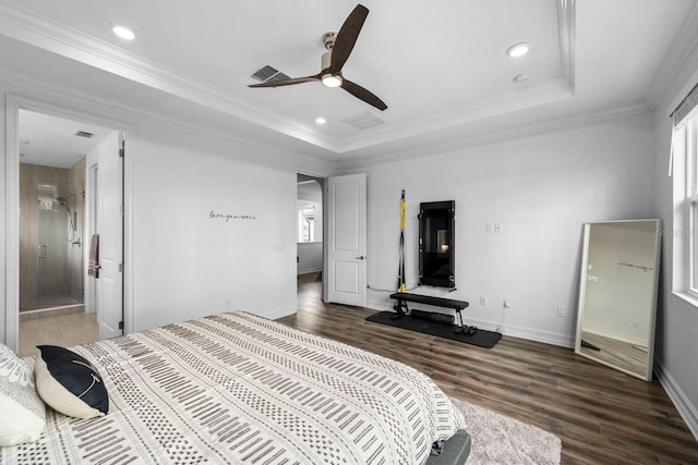 bedroom featuring ornamental molding, a tray ceiling, wood finished floors, and baseboards