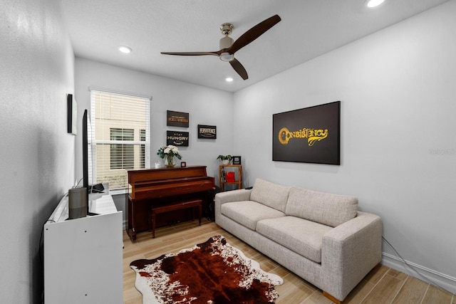 living area featuring light wood-type flooring, baseboards, a ceiling fan, and recessed lighting