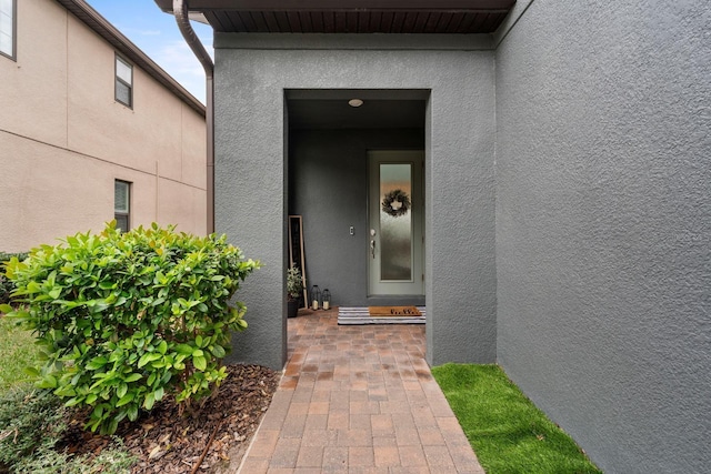 doorway to property featuring stucco siding