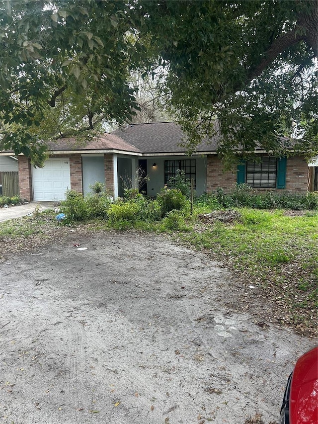 ranch-style home with brick siding, driveway, and an attached garage