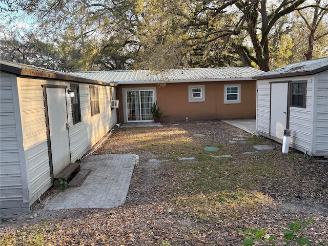 exterior space with metal roof, an outdoor structure, and a storage unit