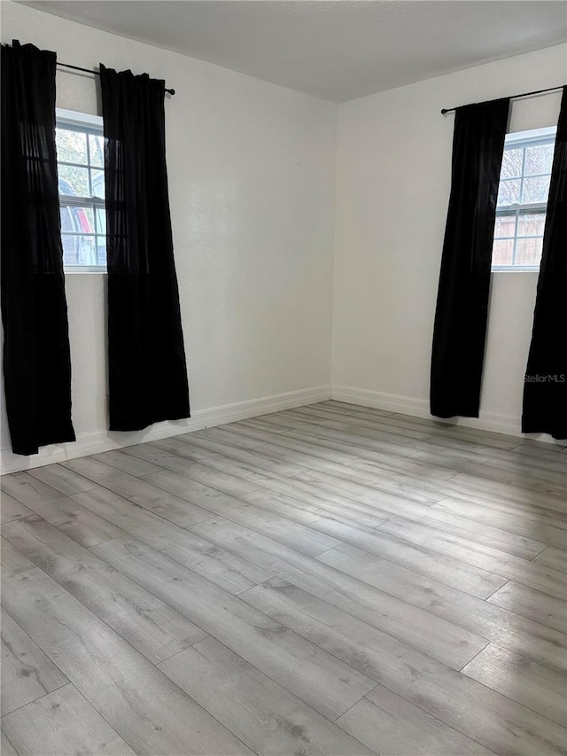 unfurnished room featuring baseboards and wood finished floors