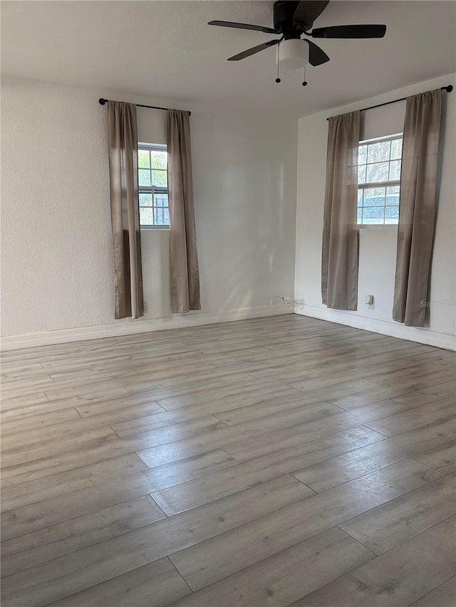 unfurnished room featuring a textured wall, wood finished floors, and a ceiling fan