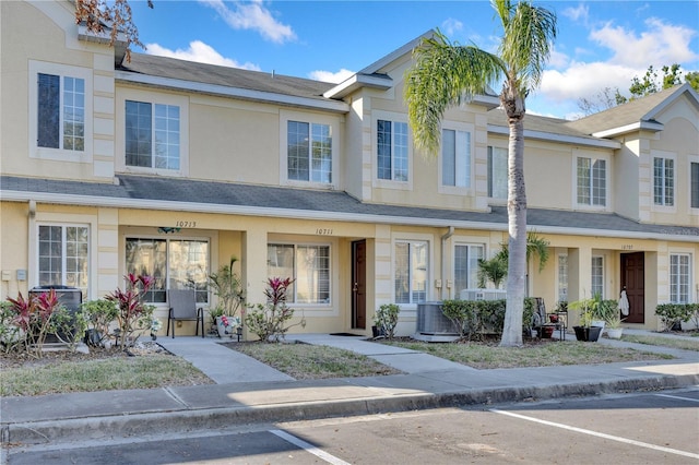 townhome / multi-family property with a shingled roof and stucco siding