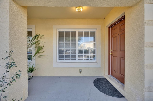 property entrance with stucco siding