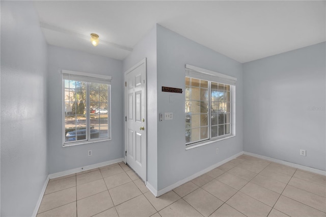 foyer entrance featuring light tile patterned flooring and baseboards