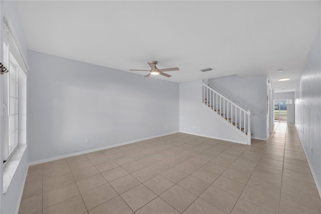 spare room with visible vents, stairway, light tile patterned flooring, ceiling fan, and baseboards