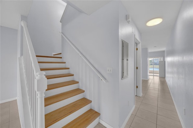 staircase featuring baseboards and tile patterned floors