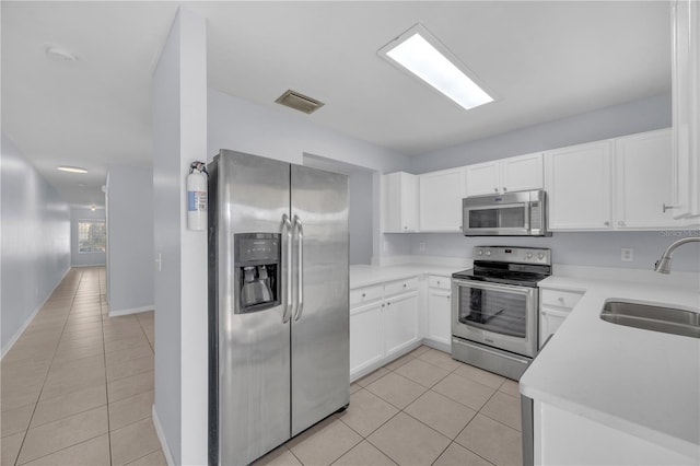 kitchen with light tile patterned flooring, a sink, visible vents, light countertops, and appliances with stainless steel finishes