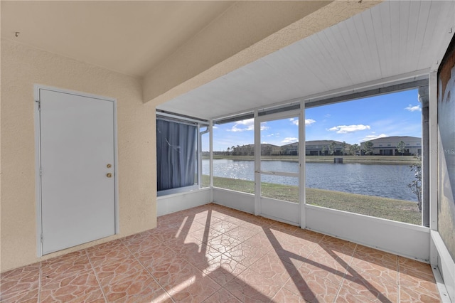 unfurnished sunroom with a water view