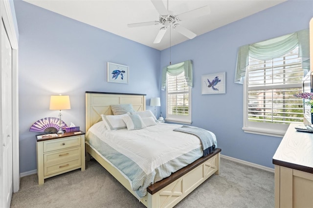 bedroom with light carpet, ceiling fan, and baseboards