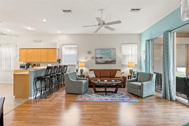 living area featuring ceiling fan, light wood-type flooring, visible vents, and recessed lighting