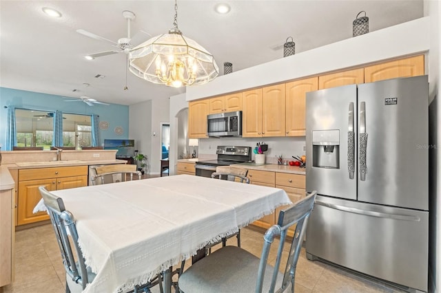 kitchen featuring light tile patterned floors, appliances with stainless steel finishes, light countertops, light brown cabinetry, and a sink