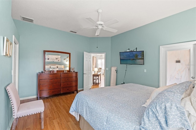 bedroom featuring a ceiling fan, wood finished floors, visible vents, and baseboards