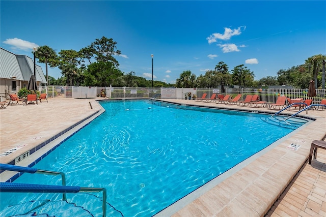 pool with a patio area and fence