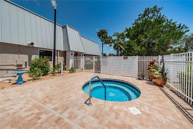 view of pool featuring a gate, a patio area, fence, and a hot tub