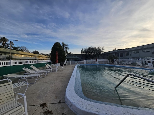 pool with fence and a patio