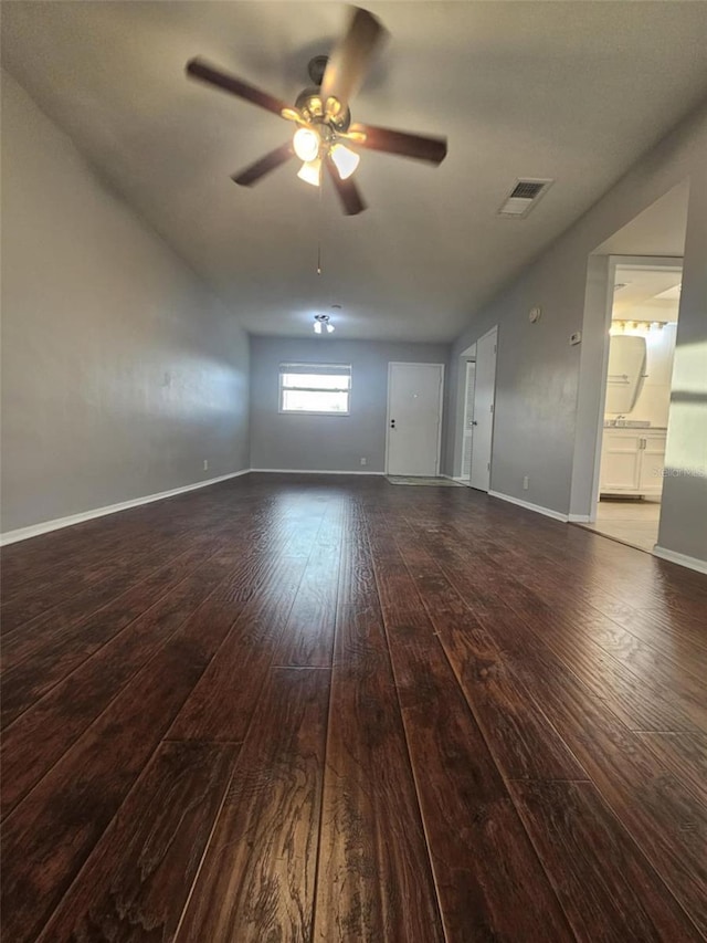 unfurnished living room featuring dark wood-style flooring, visible vents, ceiling fan, and baseboards