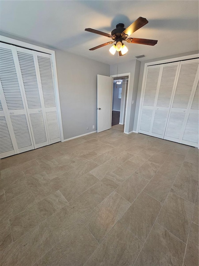 1433 S Belcher Rd Unit A12, Clearwater, FL 33764 - unfurnished bedroom featuring baseboards, ceiling fan, and two closets