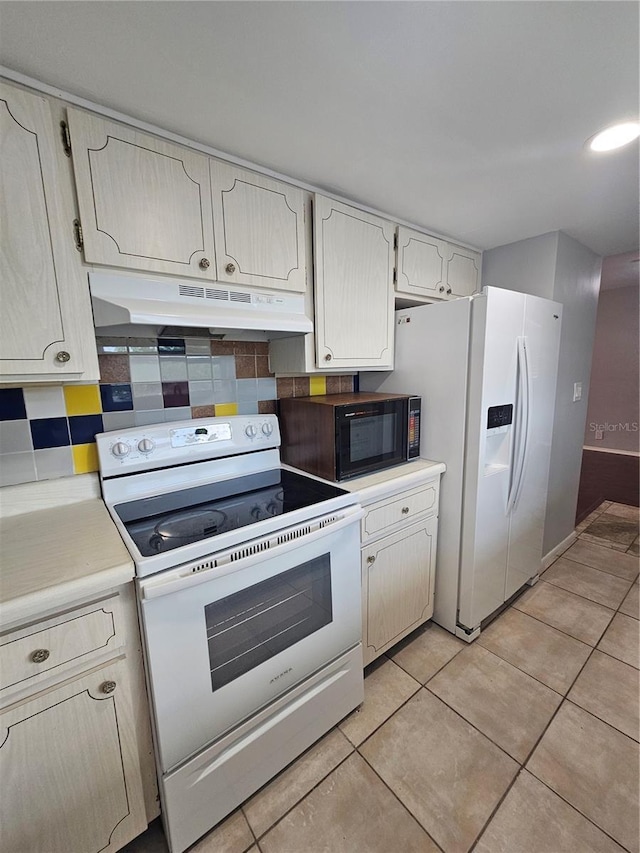 1433 S Belcher Rd Unit A12, Clearwater, FL 33764 - kitchen with white appliances, under cabinet range hood, light countertops, and light tile patterned floors